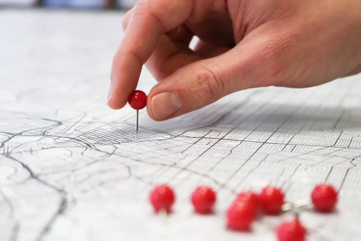 Mano che posiziona un pin su mappa: Google Business Profile